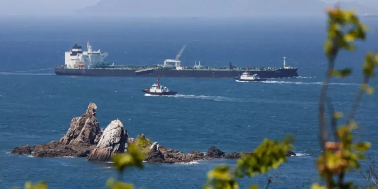 Commercial oil tanker transiting through the Strait of Hormuz under maritime surveillance.