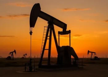 An oil pump jack operating at sunset representing global crude oil production and commodity trading