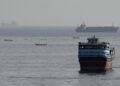 Commercial cargo vessel navigating near the Strait of Hormuz maritime passage.