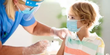 Healthcare professional administering routine vaccination to a primary school student in the UAE