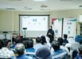 Abu Dhabi Civil Defence officers instructing industrial workers on hazardous materials handling and safety equipment.