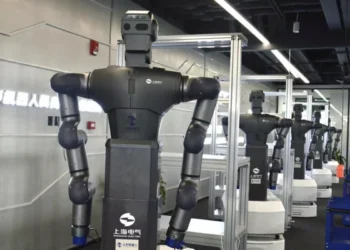 Humanoid robot undergoing motion capture training inside a simulated work facility in Hangzhou, China.
