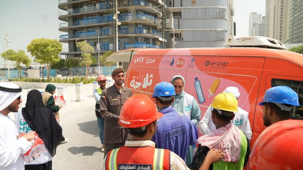 GDRFA officers distributing cold drinking water and refreshments to outdoor workers in Dubai during summer.