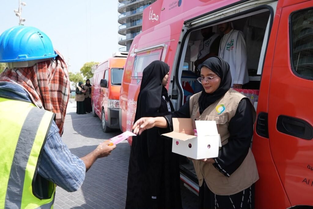 GDRFA officers distributing cold drinking water and refreshments to outdoor workers in Dubai during summer.