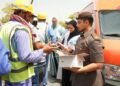 GDRFA officers distributing cold drinking water and refreshments to outdoor workers in Dubai during summer.