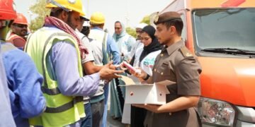 GDRFA officers distributing cold drinking water and refreshments to outdoor workers in Dubai during summer.