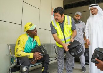 Dubai RTA official distributing health kit to motorcycle delivery rider during summer safety drive