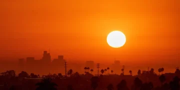 Sun shining brightly over a high-rise city skyline in the Middle East during a summer heatwave