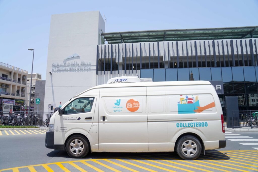 Delivery riders receiving meals at a Dubai metro station rest area during the summer midday break.