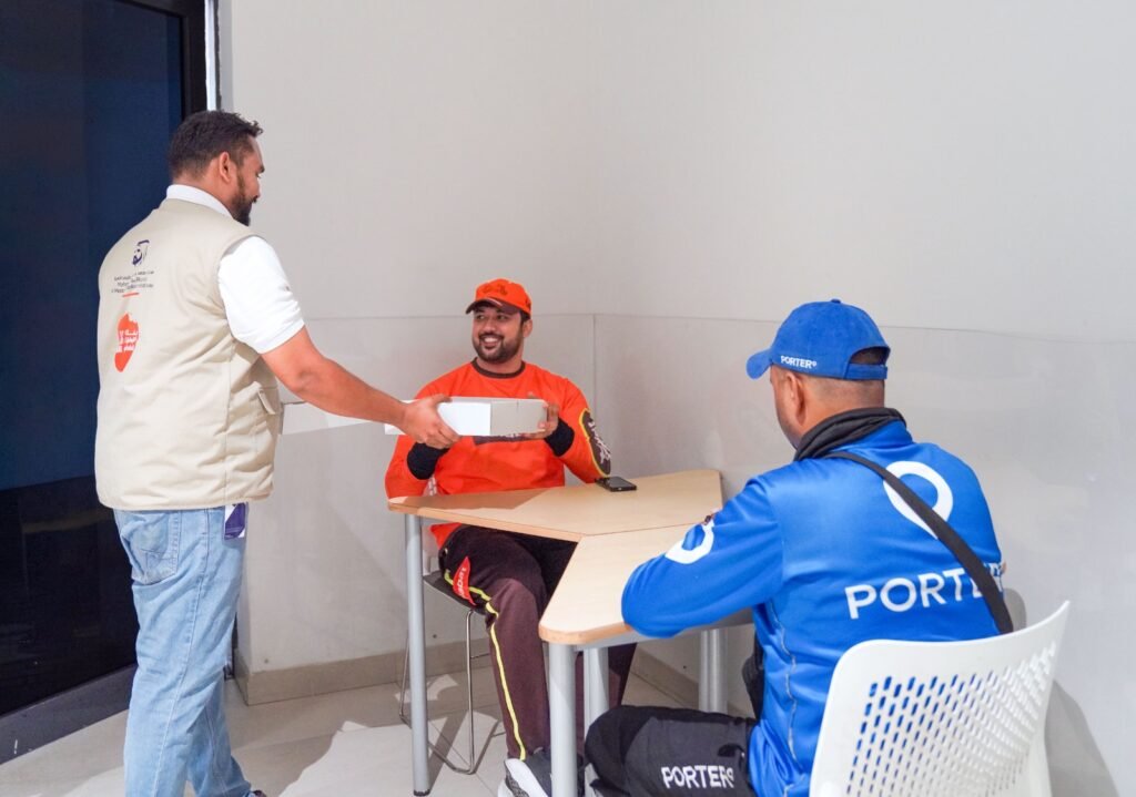 Delivery riders receiving meals at a Dubai metro station rest area during the summer midday break.