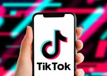 TikTok app icon displayed on a smartphone screen with the US Department of Justice seal in the background.