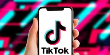 TikTok app icon displayed on a smartphone screen with the US Department of Justice seal in the background.