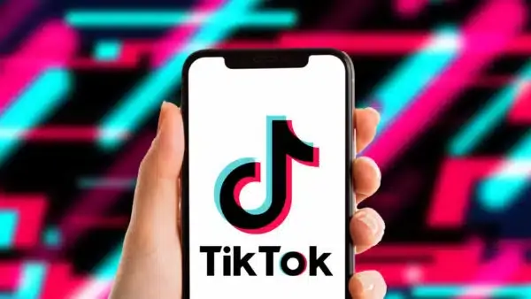 TikTok app icon displayed on a smartphone screen with the US Department of Justice seal in the background.