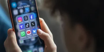 Mobile phone displaying messaging application in front of Dubai skyline silhouette.