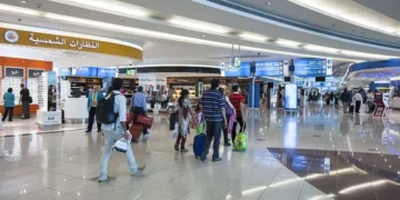 Passengers waiting at Dubai International Airport terminal amid flight cancellations and delays