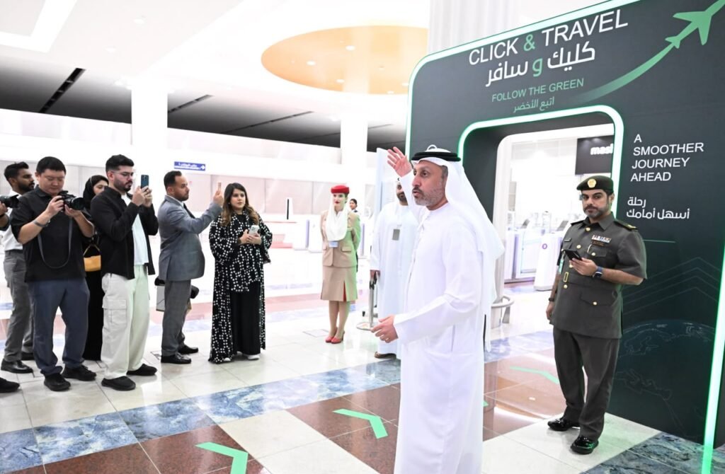 GDRFA Dubai immigration officer clearing a passenger using a portable handheld biometric terminal at Dubai International Airport.